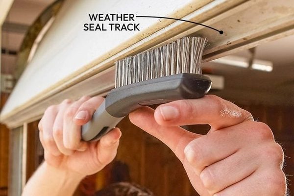 Aluminum bottom seal retainer cleaned and measured before a new coastal-grade EPDM seal install on a Norfolk 23503 garage door